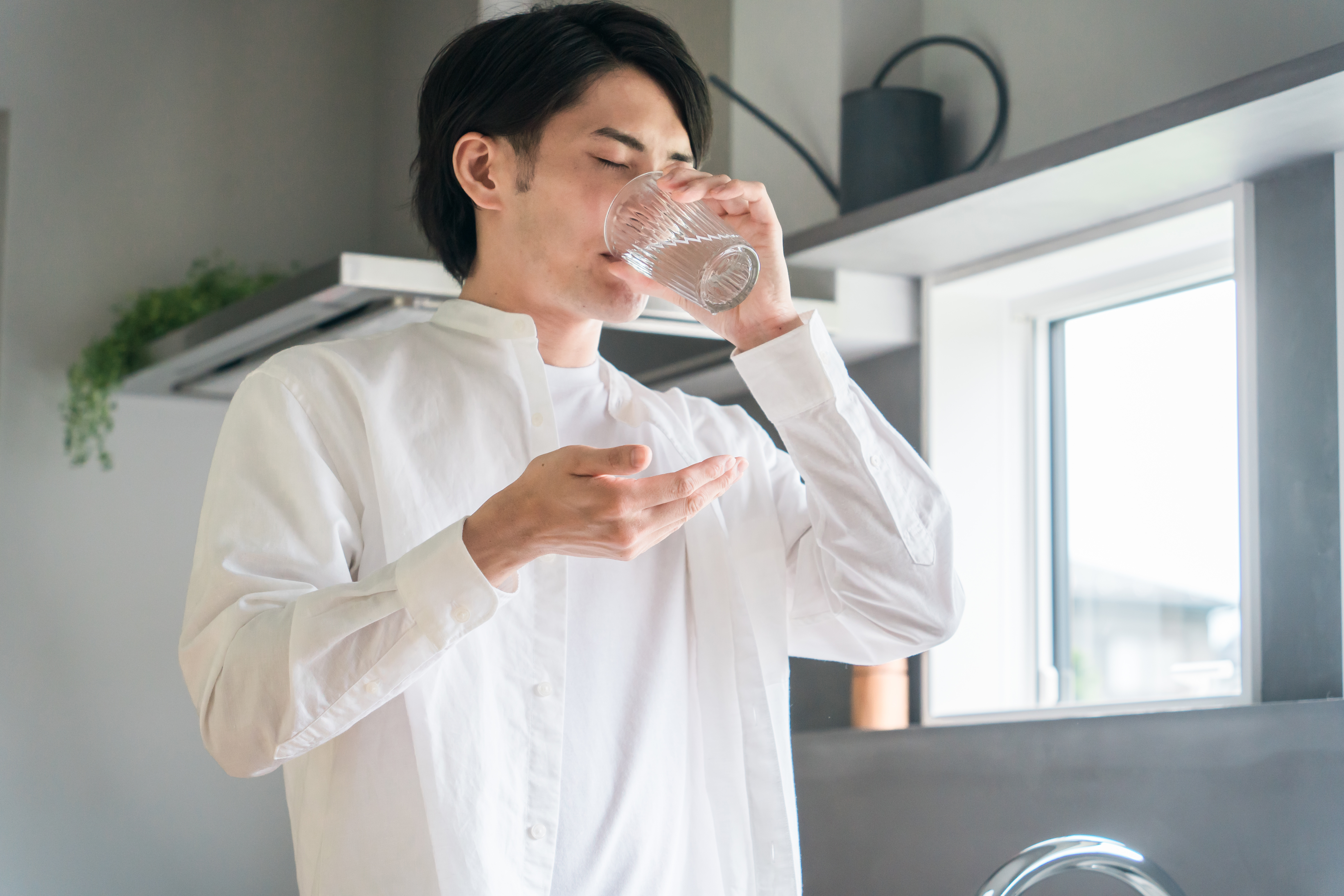 内服薬を飲む男性