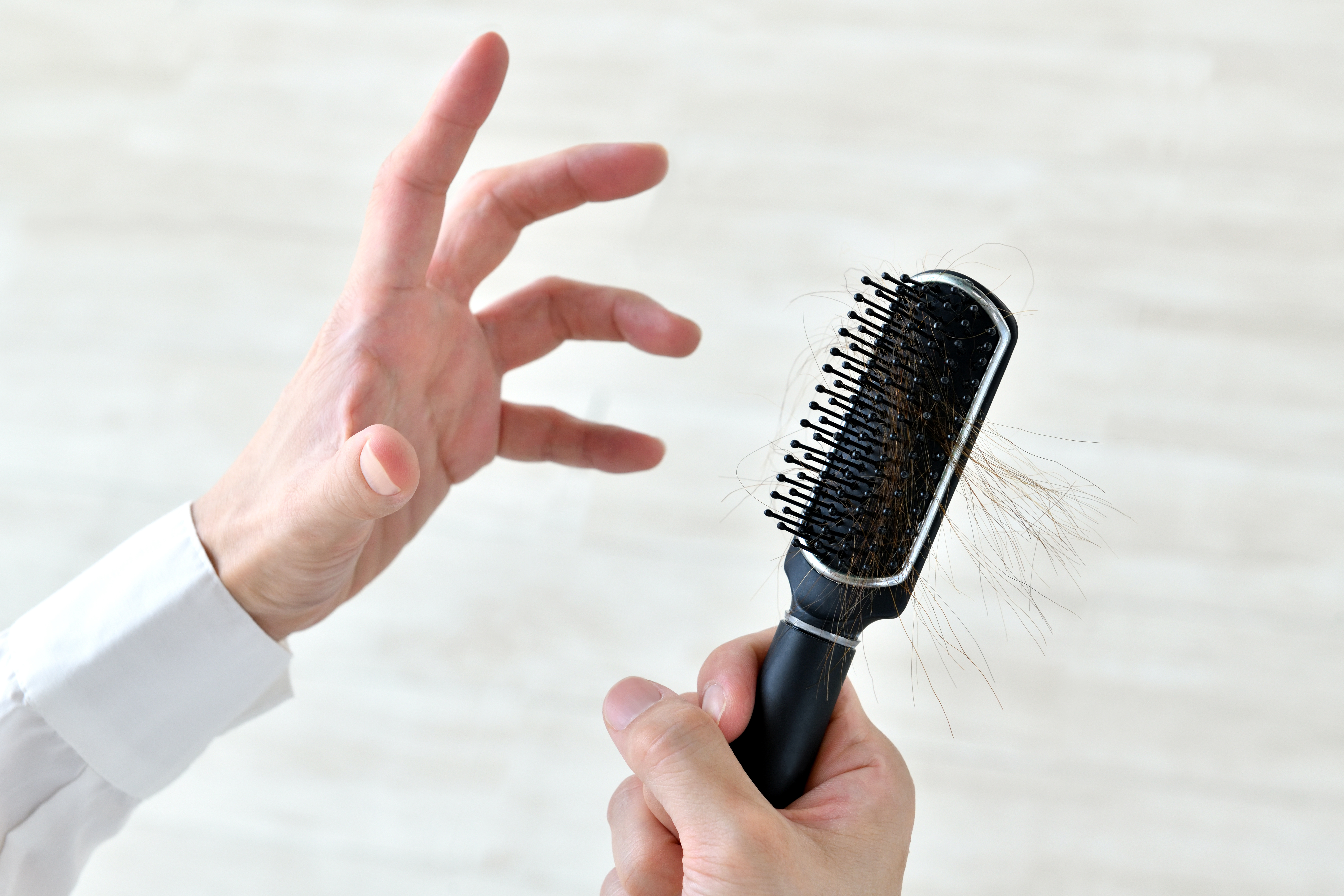 抜け毛・切れ毛にショックを受ける人物の手元