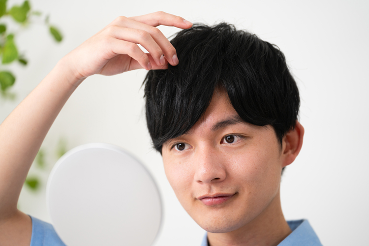手鏡を見る男性