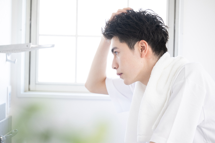 髪の毛が気になる朝の男性の洗面台での様子