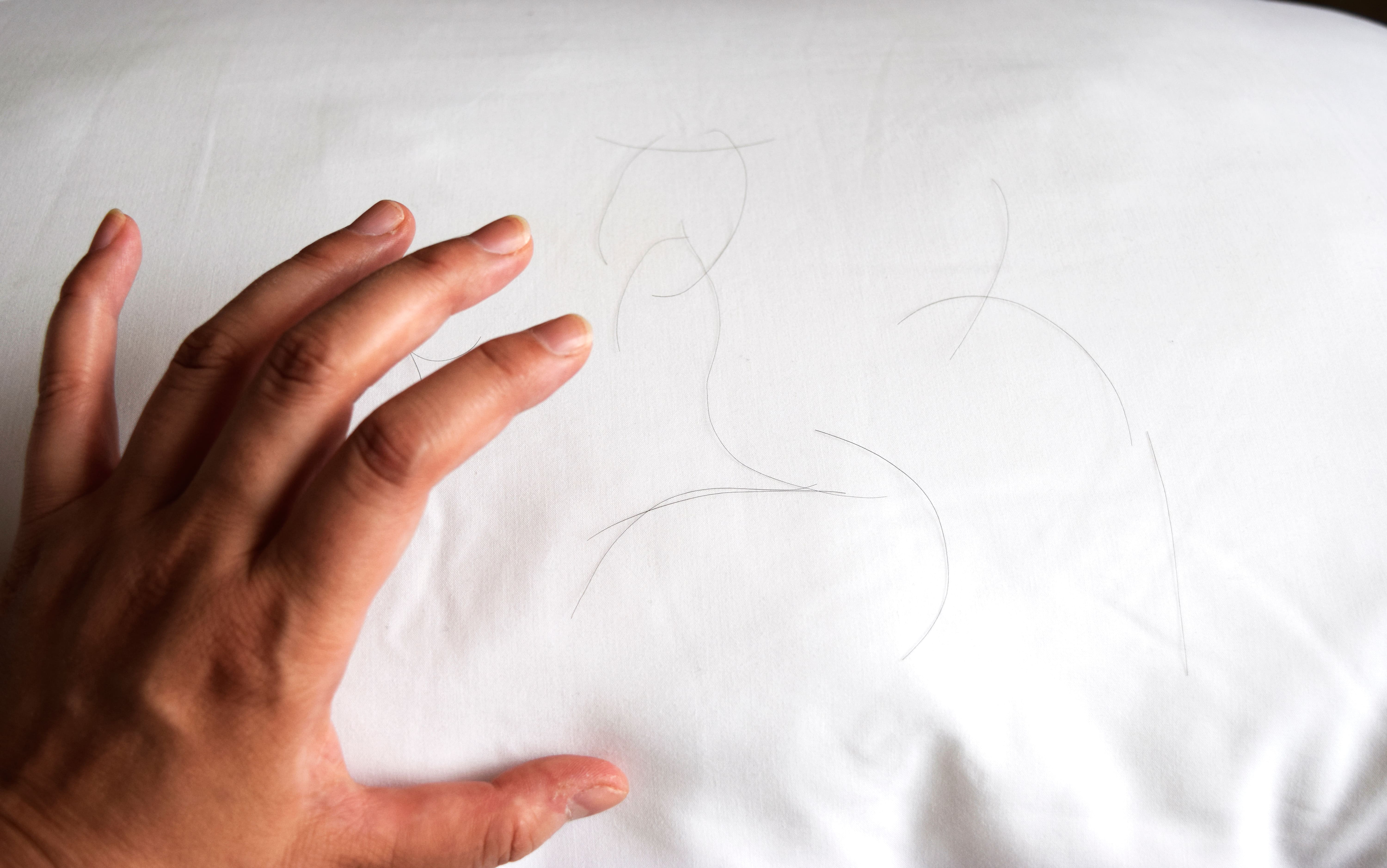 枕の上に落ちた抜け毛と、それを確認する手元