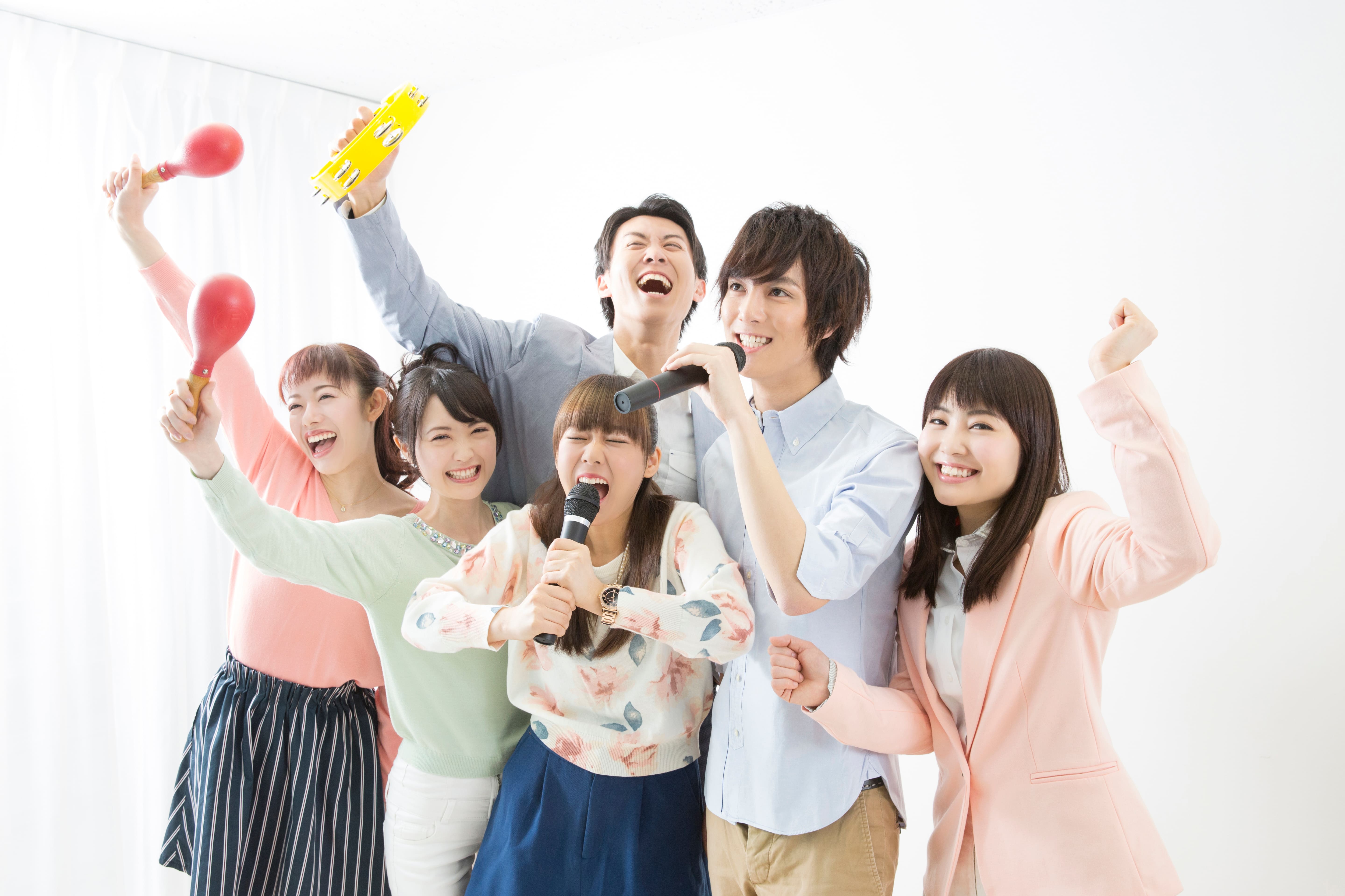 マイクを持ってカラオケを楽しむ男女のグループ