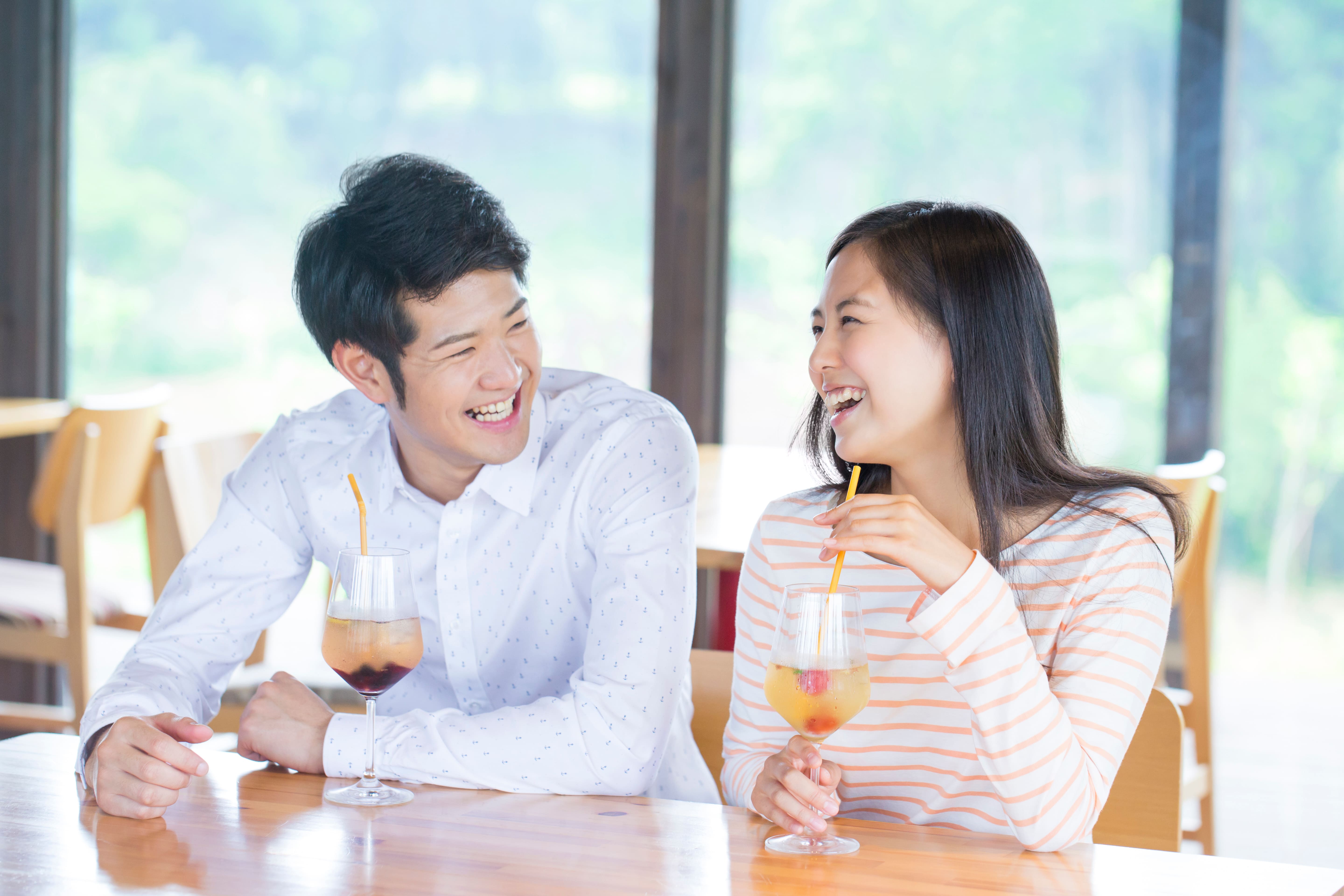 カフェで飲み物を飲みながら会話を楽しむ男女