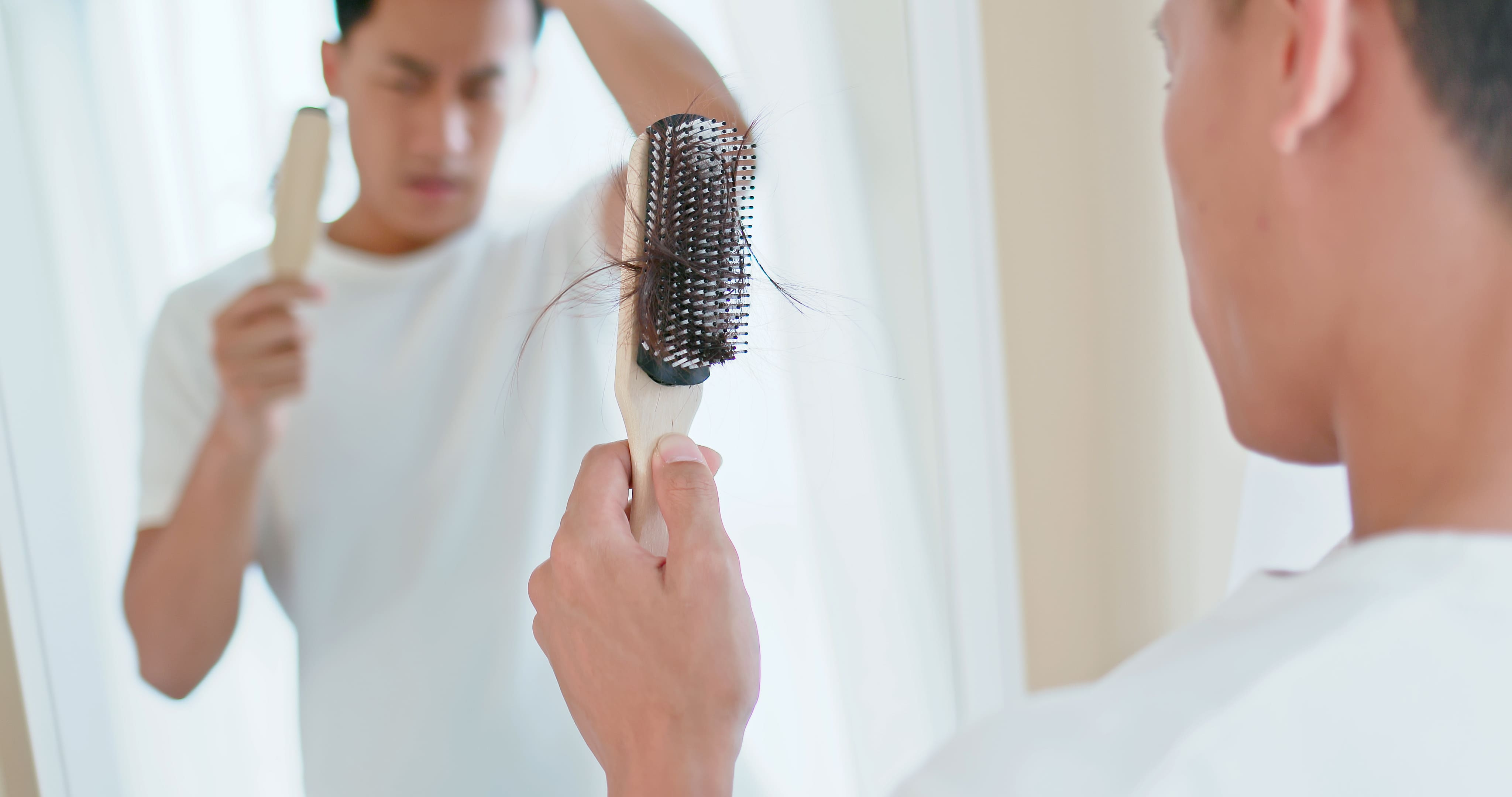 AGA（男性型脱毛症）による抜け毛を確認する男性