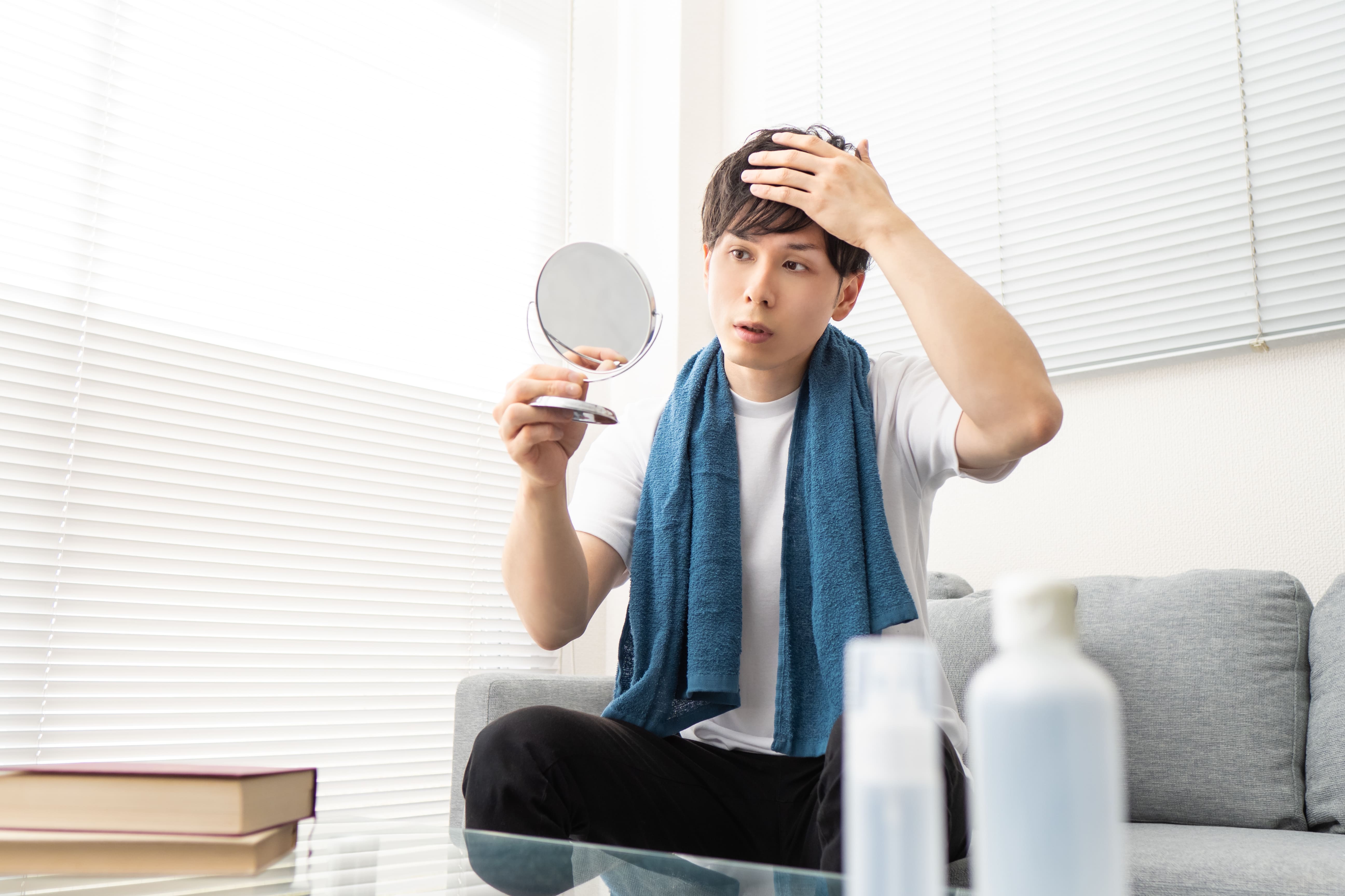 投薬治療や自毛植毛による薄毛対策を検討する男性